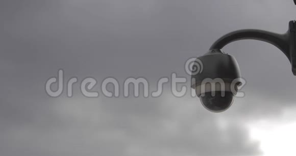 背景中灰色云层快速移动的建筑物上的监控摄像头录像视频的预览图