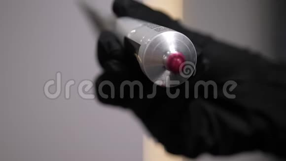 一个理发师用特写镜头把粉红色的染发剂从管子里挤出来4K视频的预览图