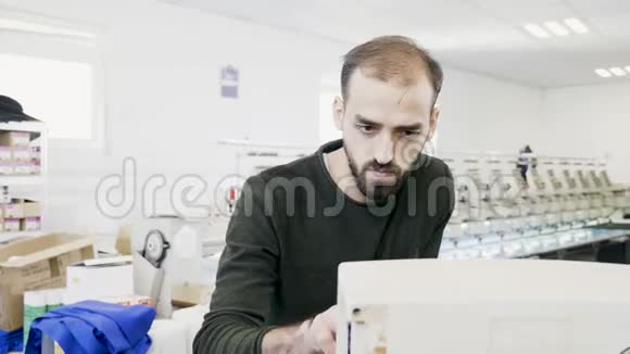 在缝纫机电脑上工作的人视频的预览图