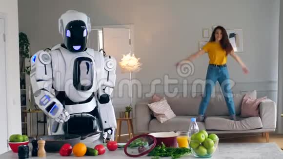 一位女士正在沙发上跳而一个机器人正在做饭视频的预览图