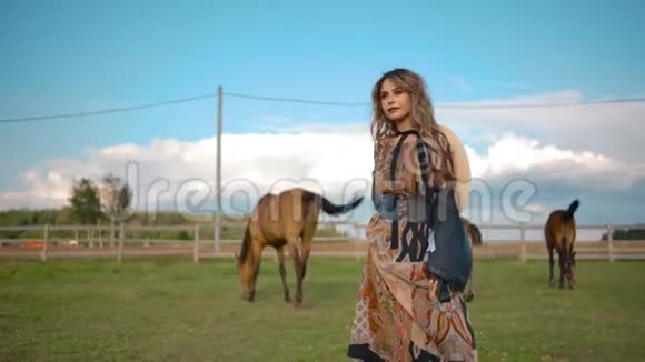 优雅的女人在牧马附近摆姿势视频的预览图