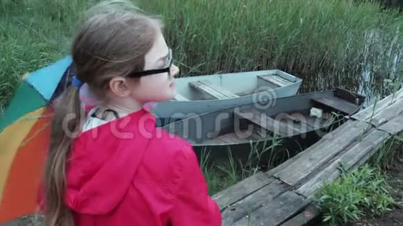 下雨天在湖边有伞的小女孩视频的预览图