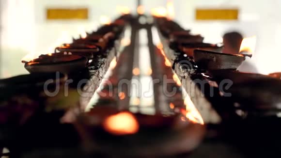 佛寺祭坛上长排燃烧蜡烛和油灯的特写4k视频视频的预览图