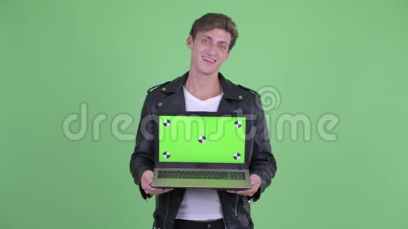 快乐的叛逆青年一边说话一边展示笔记本电脑视频的预览图
