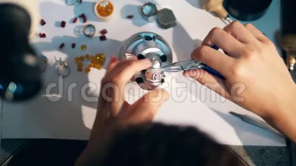 一个珠宝商用钳子拧紧戒指珠宝商金匠在一个专业的珠宝车间视频的预览图