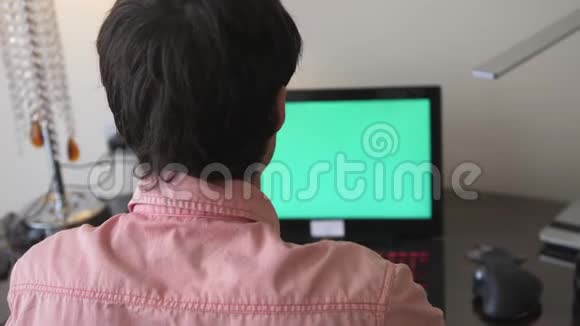 男人用绿色屏幕在笔记本电脑上工作视频的预览图