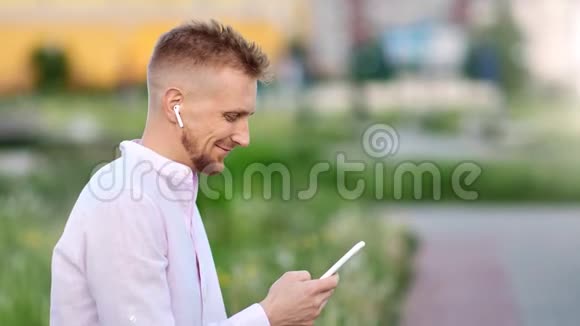 快乐的年轻帅哥戴着智能手机听音乐视频的预览图