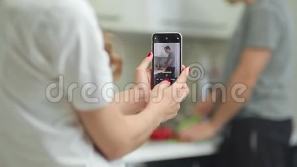 特写女人手在手机上给男人拍照视频的预览图