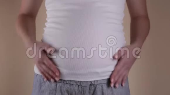 有趣的概念一个孕妇腹部的特写镜头穿着一件白色T恤摇着他的腹部视频的预览图