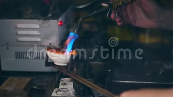 珠宝商金匠在一个专业的珠宝车间熔化金属与燃烧器在珠宝车间视频的预览图