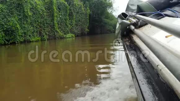 在热带丛林森林肮脏的泥泞河流上航行的塑料摩托艇4k视频视频的预览图
