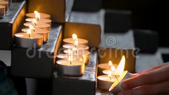 教堂里蜡烛点亮女的手在教堂点燃蜡烛视频的预览图