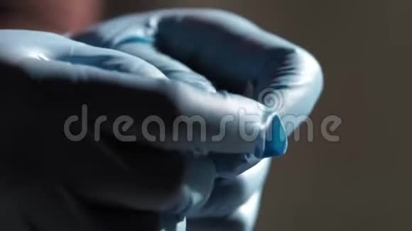 双手戴蓝手套打开水泡包里的最后一粒药丸视频的预览图