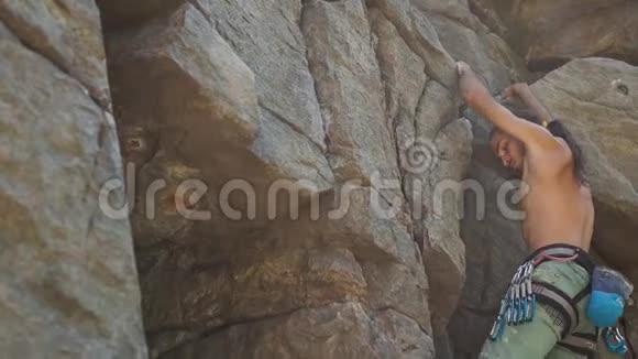 有魅力的人攀岩者爬上花岗岩悬崖伸手抓住视频的预览图