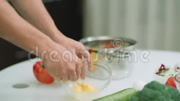 特写男人的手把鸡蛋加入锅里男人亲手烹饪食材视频的预览图