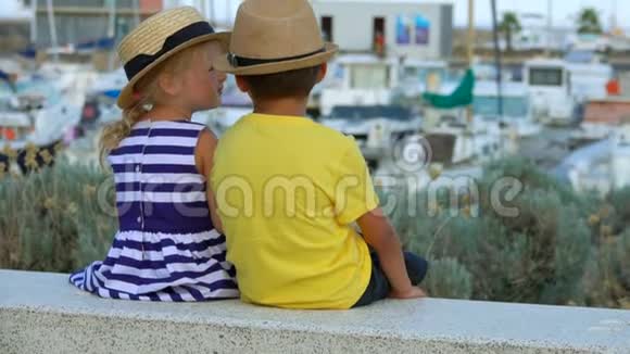 微笑的女孩坐在男孩旁边的长凳上视频的预览图