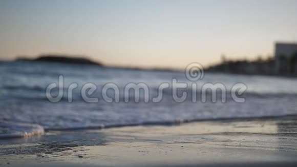 日落时分人的双腿沿着海岸线缓慢地行走视频的预览图