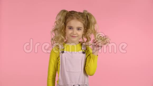 可爱的女孩子把头发缠绕在手指上视频的预览图