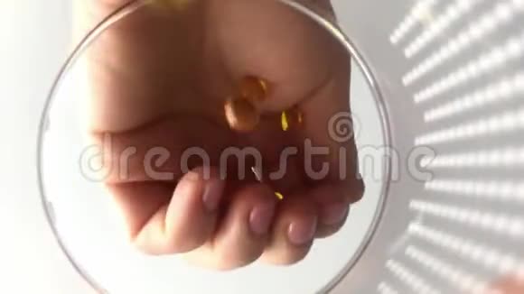 女人手把许多药丸扔进玻璃里玻璃POV视频的预览图