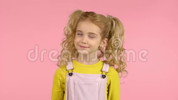 粉红背景画室里的小女可爱带着体贴和微笑的脸视频的预览图