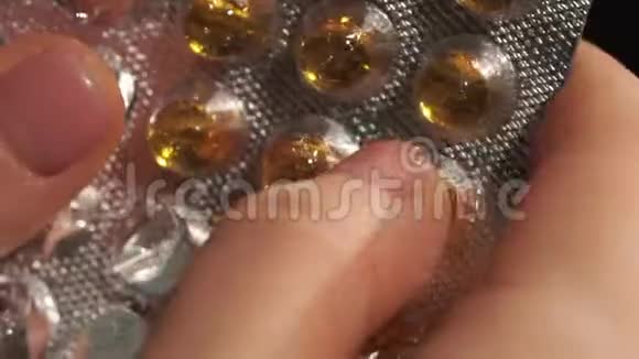 女人手从水泡中提取黄色圆形维生素视频的预览图