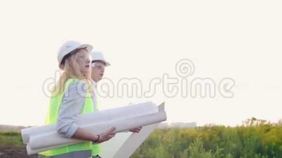 一对戴着白盔图纸的男女建筑工人去工地上谈视频的预览图