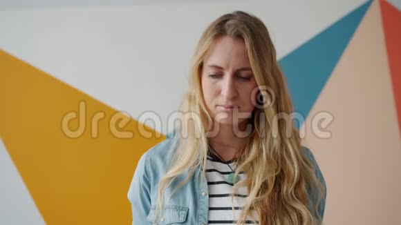不高兴的年轻女子看着镜头悲伤的脸独自站在室内视频的预览图