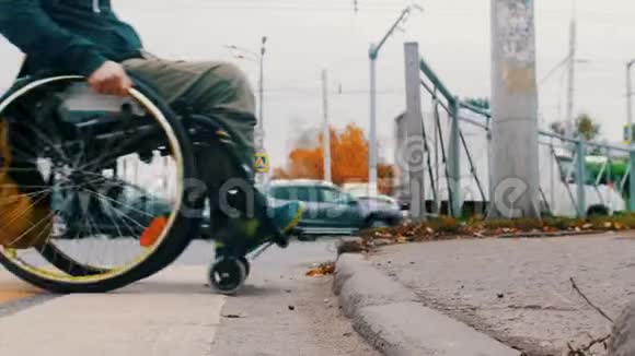 坐轮椅的残疾人试图攀登一个台阶另一个人帮助他视频的预览图
