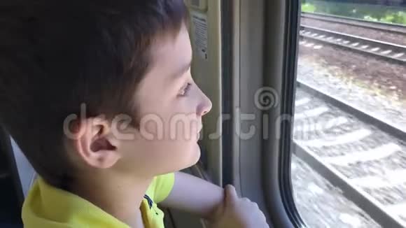 一个十几岁的男孩坐着火车透过窗户看风景视频的预览图
