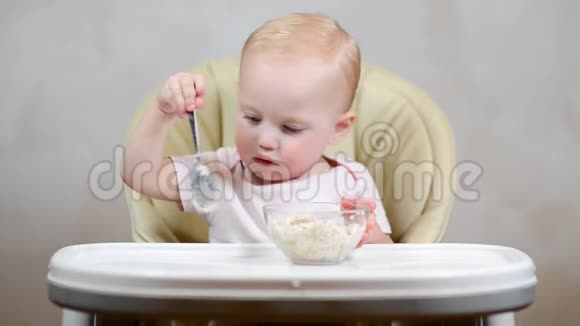 小女孩在喂饭椅上吃粥视频的预览图