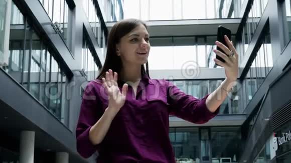 成功的女商人手里拿着手机通过视频通话视频会议办公室在视频的预览图