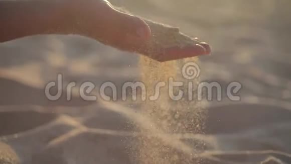 特写日落时分在热带海滩上女人的手在玩柔软的沙子背景是海水和海浪视频的预览图