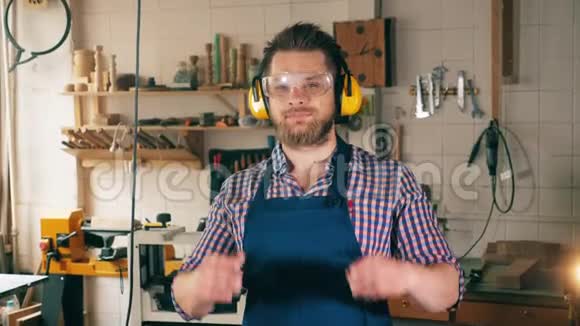木工车间木工一个穿工装的男人在做木工时微笑视频的预览图