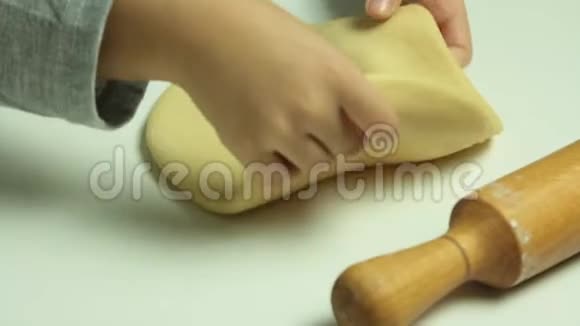 小孩在厨房玩用擀面杖伸面团视频的预览图