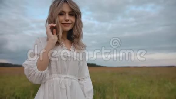 穿着裙子站在偏远乡村草地上的浪漫女人视频的预览图