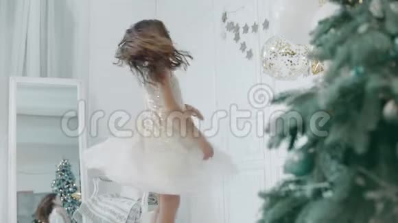 美丽的女孩穿着白色连衣裙在圣诞树附近旋转视频的预览图