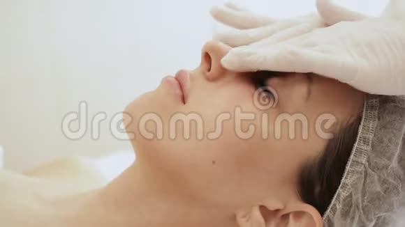 美容师做女性面部按摩按摩脸女孩特写视频的预览图