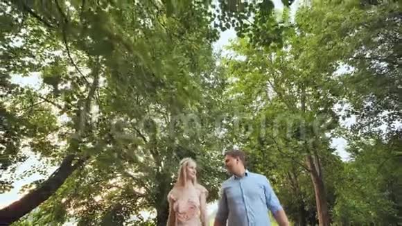 一男一女正在树下的公园里散步视频的预览图