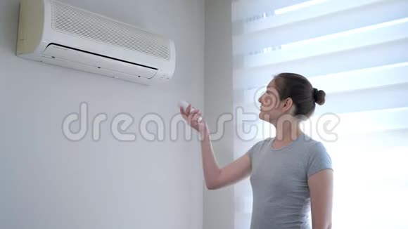 年轻的女人从遥控器打开空调视频的预览图