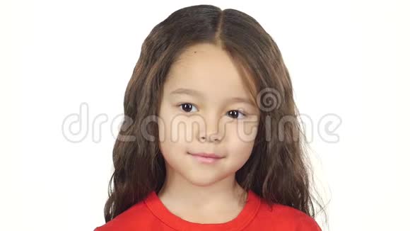特写小黑头发小孩在白色背景上微笑慢动作视频的预览图