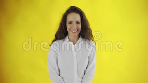 工作室里的微笑女孩肖像黄色背景上开朗的女人笑脸天生的美女视频的预览图