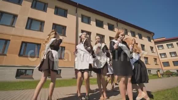 快乐的舞蹈毕业生在学校的背景下跳舞学生们很高兴毕业视频的预览图