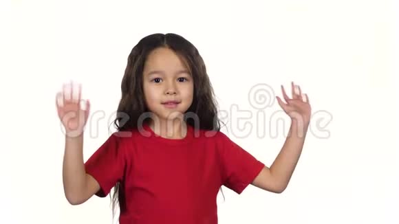 小黑头发的女孩用手在白色的背景上挥手慢动作视频的预览图