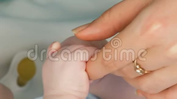 两个月刚出生的婴儿的小手握着母亲的手指视频的预览图