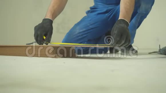 修理工坐着测量瓷砖的长度视频的预览图