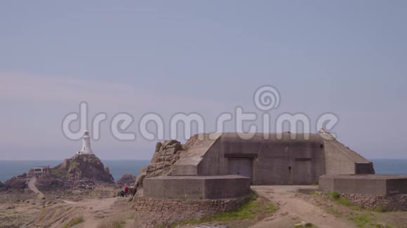一座灯塔和一座建造在岩石海滩上的木屋视频的预览图