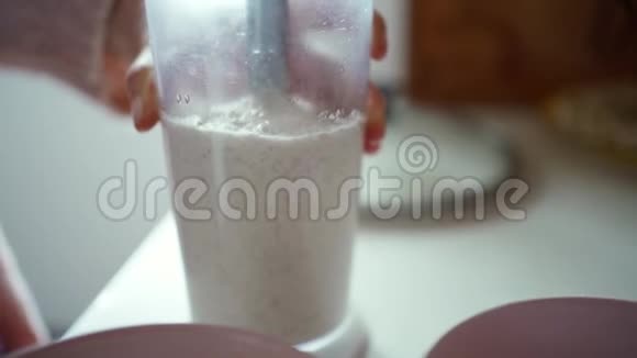 用手搅拌机将女性的双手合拢制成健康的食物冰沙视频的预览图