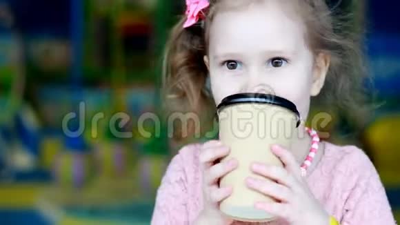 孩子在喝咖啡一个喝一杯的可爱女婴的特写镜头视频的预览图