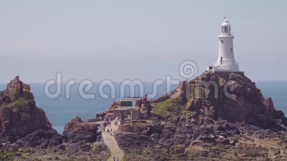 一座灯塔建在岩石海滩的山丘上视频的预览图