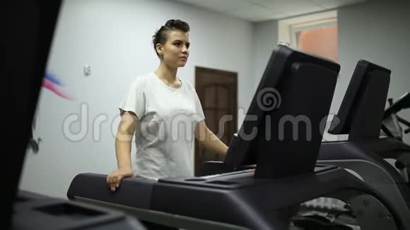 那个女孩在健身房跑步机上跑步视频的预览图